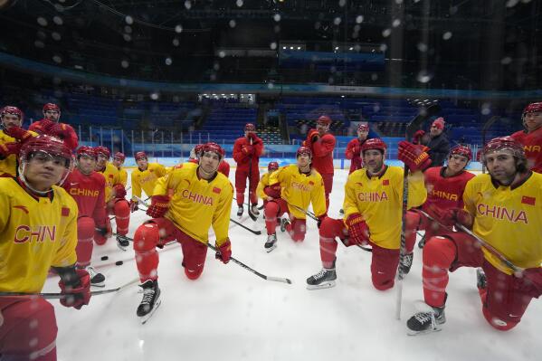 China players listen to their coaching staff during a men's hockey practice session at the 2022 Winter Olympics, Sunday, Jan. 30, 2022, in Beijing. (AP Photo/Petr David Josek)