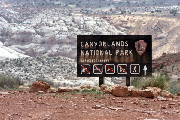 FILE - A sign for Canyonlands National Park is seen, May 6, 2003, in Moab, Utah. Three hikers died over the weekend in suspected heat-related incidents at parks in Utah, including a father and daughter who got lost on a strenuous hike in Canyonlands National Park in triple-digit temperatures. The Canyonlands hikers died Friday, July 12, 2024, while a third deceased hiker was found in Utah's Snow Canyon State Park. (AP Photo/Mickey Krakowski, File)