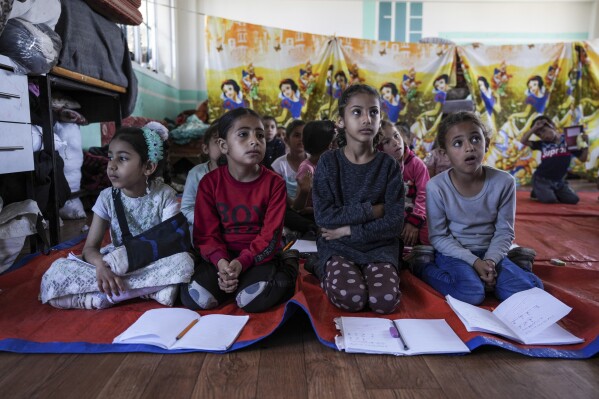 Children attend an activity at a makeshift class in Deir al Balah, on Sunday, April 21, 2024. Since the war erupted Oct 7, all schools in Gaza have closed, and nearly 90% of school buildings are damaged or destroyed, according to aid groups. (AP Photo/Abdel Kareen Hana)