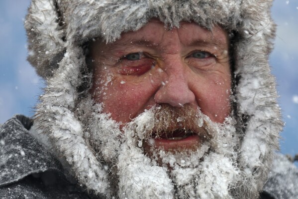 FILE - A worker pauses while removing snow from Highmark Stadium in Orchard Park, N.Y., Jan. 14, 2024. While the U.S. is shivering through bone-chilling cold, most of the rest of world is feeling unusually warm weather. Scientists Tuesday, Jan. 16, say that fits with what climate change is doing to Earth. (AP Photo/ Jeffrey T. Barnes, File)