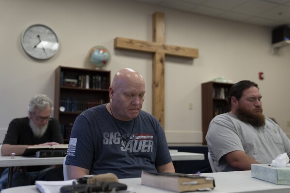 Brian Wright, center, prays during bible study at Gospel Rescue Mission, Thursday, March 21, 2024, in Grants Pass, Ore. (AP Photo/Jenny Kane)