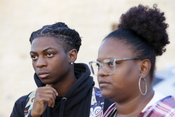 Darryl George, left, a 17-year-old junior, and his mother Darresha George, right, talks with reporters before walking across the street to go into Barbers Hill High School after Darryl served a 5-day in-school suspension for not cutting his hair Monday, Sept. 18, 2023, in Mont Belvieu. (AP Photo/Michael Wyke)
