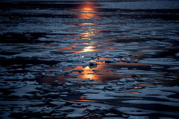FILE - The midnight sun shines across sea ice along the Northwest Passage in the Canadian Arctic Archipelago, July 23, 2017. A new study Wednesday, March 15, 2023, says the thickness of sea ice dropped sharply in two sudden events about 15 years ago. (AP Photo/David Goldman, File)