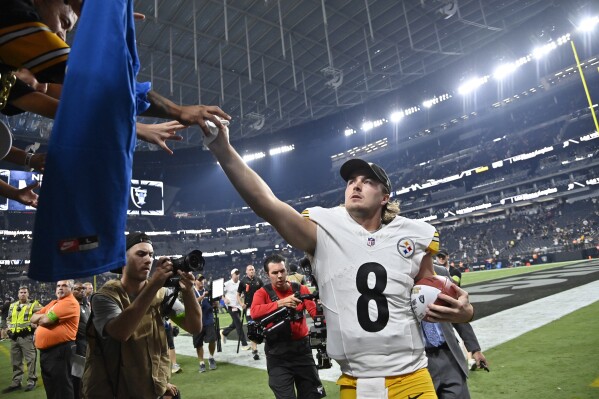 Pittsburgh Steelers quarterback Kenny Pickett gives his glove to a fan in the stands after a win over the Las Vegas Raiders during an NFL football game Sunday, Sept. 24, 2023, in Las Vegas. (AP Photo/David Becker)