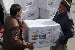 FILE- Afghan health ministry workers unloads boxes of the first shipment of 500,000 doses of the AstraZeneca coronavirus vaccine made by Serum Institute of India, donated by the Indian government, at the customs area of the Hamid Karzai International Airport, in Kabul, Afghanistan, Sunday, Feb. 7, 2021. India has delivered two tons of medicines to Afghanistan, although it has not officially recognized its Taliban government. A government spokessperson says the medicine was given to Kabul's Indira Gandhi Hospital, which was set up with Indian assistance in 2004. Last month, India supplied Afghanistan with 500,000 doses of COVID-19 vaccines and 1.6 tons of medical supplies through the World Health Organization. (AP Photo/Rahmat Gul, file)