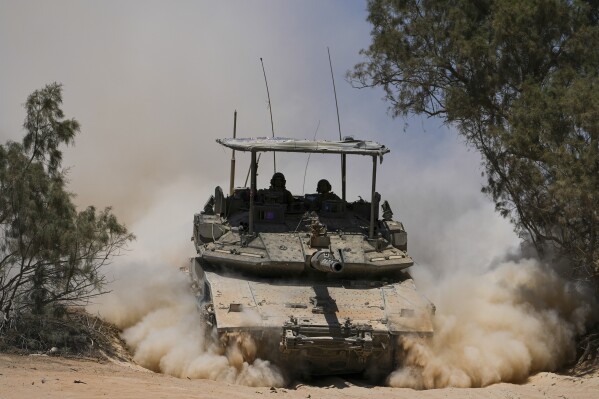 Israeli soldiers drive a tank near the Israeli-Gaza border, in southern Israel, Wednesday, May 29, 2024. (AP Photo/Tsafrir Abayov)