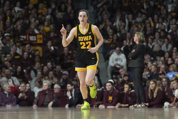 Iowa guard Caitlin Clark (22) points after an Iowa basket scored during the first half of an NCAA college basketball game against Minnesota, Wednesday, Feb. 28, 2024, in Minneapolis. (AP Photo/Abbie Parr)