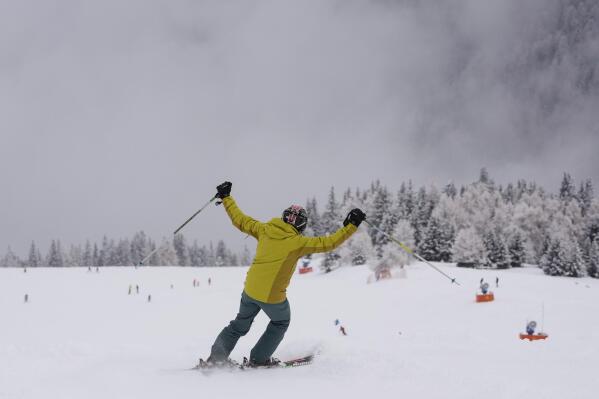 A tourist gestures while skiing, at Plan de Corones ski area, Italy South Tyrol, Saturday, Nov. 27, 2021. After nearly two years of being restricted to watching snow accumulate on distant mountains, Italian skiers are finally returning to the slopes that have been off limits since the first pandemic lockdown in March 2020. But just as the industry is poised to recover from a lost 2020-2021 season after an abrupt closure the previous year, a spike in cases in the Alpine province bordering Austria is underlining just how precarious the situation remains. (AP Photo/Luca Bruno)