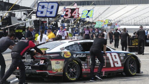 Race team members push the No. 19 car of Martin Truex Jr. onto the pit road before the Crayon 301 NASCAR Cup Series race Monday, July 17, 2023, at New Hampshire Motor Speedway, in Loudon, N.H. (AP Photo/Steven Senne)