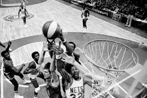 FILE - Denver Nuggets' Bobby Jones, second left, Nets' Julius Erving, fourth left, and New York Nets' Jim Eakins, right, battle for a rebound during the ABA championship playoff game at the Nassau Coliseum in Uniondale, N.Y., on May 14, 1976. The Denver Nuggets are the last of the four ABA teams that merged with the NBA to reach the Finals and is stirring up fond memories of the defunct league. (AP Photo/Richard Drew, File)