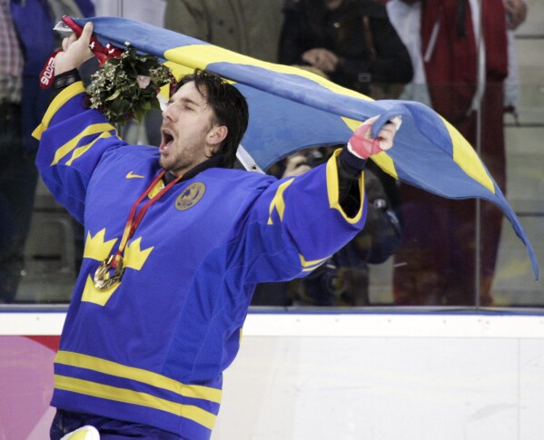 FILE - Sweden's goalie Henrik Lundqvist, of the NHL New York Rangers, celebrates after beating Finland 3-2 to win the gold medal in the 2006 Winter Olympics men's ice hockey gold medal game in Turin, Italy, Feb. 26, 2006. NHL players are returning to the Olympics for the first time in more than a decade. The world's top hockey league will allow its players to participate in the Games in 2026 in Milan and in 2030 under an agreement announced Friday, Feb. 2, 2024, by the NHL, the NHL Players’ Association, International Ice Hockey Federation and the IOC. (AP Photo/Gene J. Puskar, File)