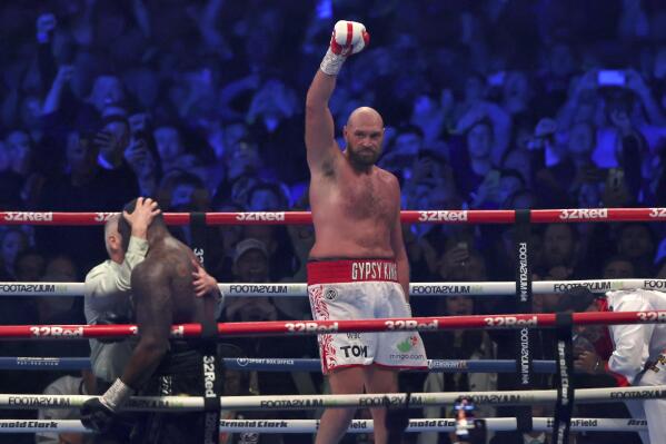FILE - Britain's Tyson Fury, center, celebrates after beating Britain's Dillian Whyte during their WBC heavyweight title boxing fight at Wembley Stadium in London, Saturday, April 23, 2022. Tyson Fury will defend his WBC heavyweight title against fellow Briton Derek Chisora in London on Dec. 3. It will be the unbeaten Fury’s first fight since knocking out another British heavyweight, Dillian Whyte, in front of 94,000 spectators at London’s Wembley Stadium in April. (AP Photo/Ian Walton, File)
