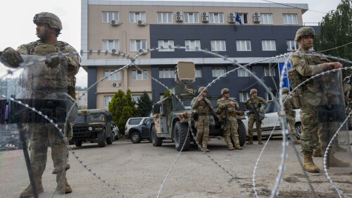 FILE - US soldiers, part of the peacekeeping mission in Kosovo KFOR guard a municipal building in the town of Leposavic, northern Kosovo, on May 29, 2023. The European Union has summoned the leaders of Serbia and Kosovo for emergency talks on Thursday June 22, 2023 to try to bring an end to a series of violent clashes near their border that is fueling fears of a return to open conflict. (AP Photo/Marjan Vucetic, File)