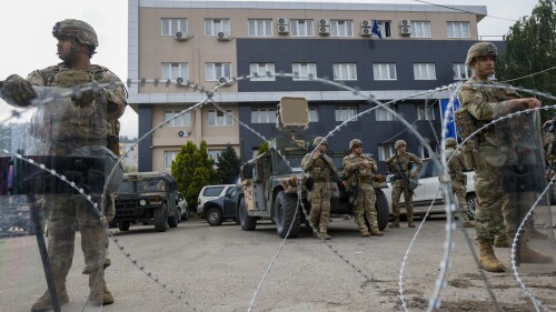 PLIK – Żołnierze amerykańscy, część misji pokojowej KFOR w Kosowie, strzegą budynku społeczności w mieście Leposavic w północnym Kosowie, 29 maja 2023 r.  Unia Europejska zwołała przywódców Serbii i Kosowa na nadzwyczajne rozmowy w czwartek, 22 czerwca 2023 r., aby spróbować zakończyć serię gwałtownych starć w pobliżu ich granic, które wzbudziły obawy o powrót, wywołując konflikty.  (AP Photo/Marjan Vucetic, plik)