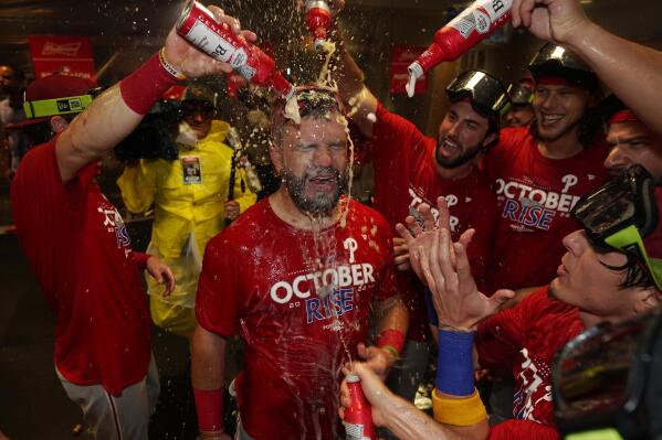 Philadelphia Phillies' Kyle Schwarber, center, celebrates with teammates after the Phillies won a baseball game against the Houston Astros to clinch a wild-card playoff spot, Monday, Oct. 3, 2022, in Houston. (AP Photo/David J. Phillip)