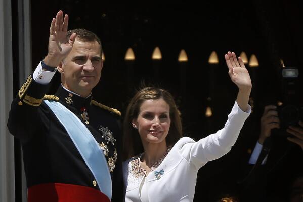 FILE - Spain's King Felipe VI and his wife Spain's Queen Letizia wave to the crowd on a balcony of the Royal Palace in Madrid, Spain, on Thursday, June 19, 2014. Spain’s Queen Letizia turned 50 on Thursday, Sept. 15, 2022. Spain is taking the opportunity to assess its scarred monarchy and ponder how the arrival of a middle-class commoner may help shake one of Europe’s most storied royal dynasties into a modern and more palatable institution. (AP Photo/Emilio Morenatti, File)