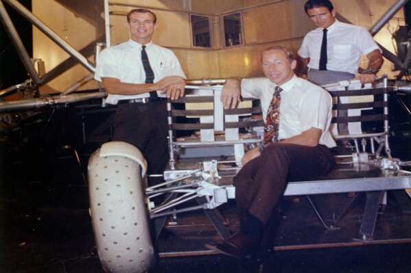 This undated photo made available by NASA shows astronauts Al Worden, center, Dave Scott, left, and Jim Irwin with a moon rover mock-up. Worden, who circled the moon alone in 1971 while his two crewmates tried out the first lunar rover, has died at age 88, his family said Wednesday, March 18, 2020. (NASA via AP)