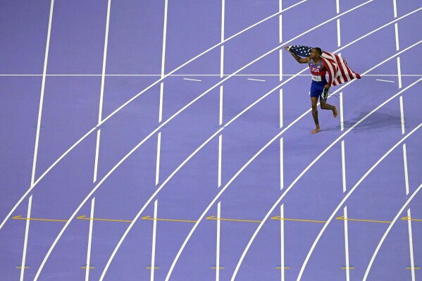 Quincy Hall, of the United States, celebrates after winning the men's 400-meter final at the 2024 Summer Olympics, Wednesday, Aug. 7, 2024, in Saint-Denis, France. (AP Photo/David J. Phillip)