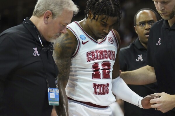 Alabama guard Latrell Wrightsell Jr. is helped off the court after going down with an injury during the first half of a second-round college basketball game against Grand Canyon in the NCAA Tournament in Spokane, Wash., Sunday, March 24, 2024. (AP Photo/Ted S. Warren)