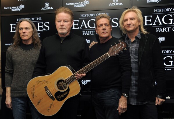Members of The Eagles, from left, Timothy B. Schmit, Don Henley, Glenn Frey and Joe Walsh pose with an autographed guitar after a news conference at the Sundance Film Festival, Jan. 19, 2013, in Park City, Utah. (Photo by Chris Pizzello/Invision/AP, File)