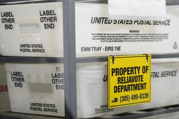FILE - U.S. Postal Service bins are lined up to hold vote-by-mail ballots for scanning during the midterm election at the Miami-Dade County Elections Department, Nov. 8, 2022, in Miami. Republicans are re-evaluating their antipathy to mail voting. After former President Donald Trump condemned that method of casting ballots in 2020, conservatives shied away from it. That's given Democrats a multiweek jump on voting during elections. (AP Photo/Lynne Sladky, File)