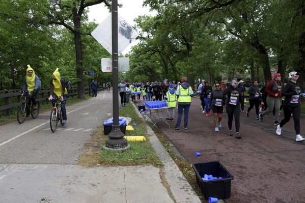 Runners get hydration via Hiccup, a reusable silicone cup, during the PNC Women Run the Cities race on Saturday, May 17, 2025, in Minneapolis. (AP Photo/Ellen Schmidt)