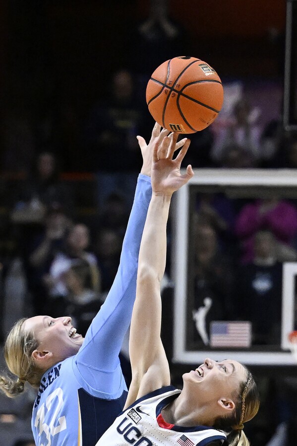 FILE - UConn guard Paige Bueckers (5) wins the tip over Marquette during the first half of an NCAA college basketball game in the semifinals of the Big East Conference tournament at Mohegan Sun Arena, Sunday, March 10, 2024, in Uncasville, Conn. As March Madness is set to tip off, three of the most recognizable names in college basketball are in the women’s tournament: Caitlin Clark, Angel Reese and Paige Bueckers. (AP Photo/Jessica Hill, File)
