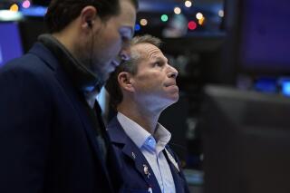 FILE - Trader Robert Charmak, right, works on the floor of the New York Stock Exchange, Tuesday, Dec. 7, 2021. At the center of the investing world are Treasurys, the IOUs the U.S. government gives to investors who lend it money. The yield curve is a chart showing how much in interest different Treasurys are paying.    (AP Photo/Richard Drew, File)