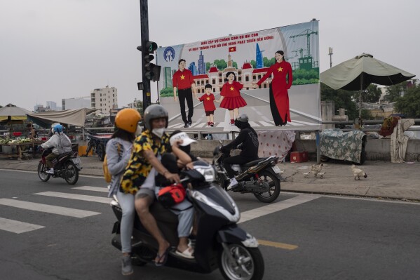 A billboard campaigning for each family to have two children in an effort to improve the birth rate stands along the street in Ho Chi Minh City, Vietnam, Jan. 14, 2024. (AP Photo/Jae C. Hong)
