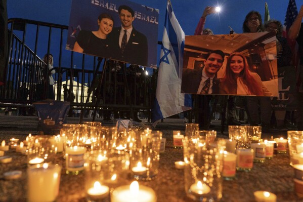 People gather to light candles in a makeshift memorial to honor Yaron Lischinsky and Sarah Milgrim who were killed as they left an event at the Capital Jewish Museum in Washington, during a candlelight vigil outside of the White House in Washington, Thursday, May 22, 2025. (AP Photo/Jose Luis Magana, file)