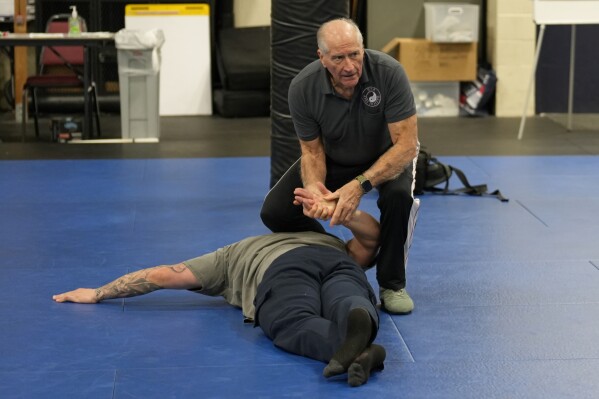 Instructor Dave Rose demonstrates a prone handcuffing position on a student during an Arrest & Control Instructor course in Sacramento, Calif., on Thursday, Jan. 18, 2024. Rose has trained generations of officers that prone restraint is safe. His pupils are instructors who take his training back to their departments. (AP Photo/Rich Pedroncelli)