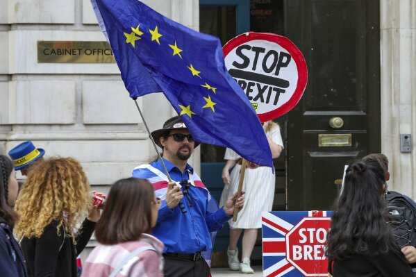 Anti-Brexit protesters demonstrate outside the Cabinet Office in Whitehall in London on Thursday, Aug. 15, 2019.  Demonstrations for both sides of the Brexit debate continue around parliament, as Prime Minister Boris Johnson has vowed that Britain will leave the EU on Oct. 31,  with or without a Brexit deal. (AP Photo/ Vudi Xhymshiti)