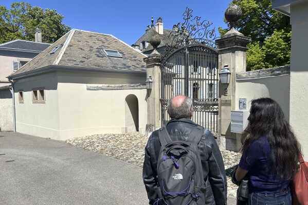 Reporters stand outside the residence of the Swiss ambassador to the United Nations where talks between U.S. Treasury Secretary, America’s top trade negotiator, and high-ranking Chinese officials are believed to be taking place, in Geneva, Switzerland, Saturday, May 10, 2025. (AP Photo/Jamey Keaten)