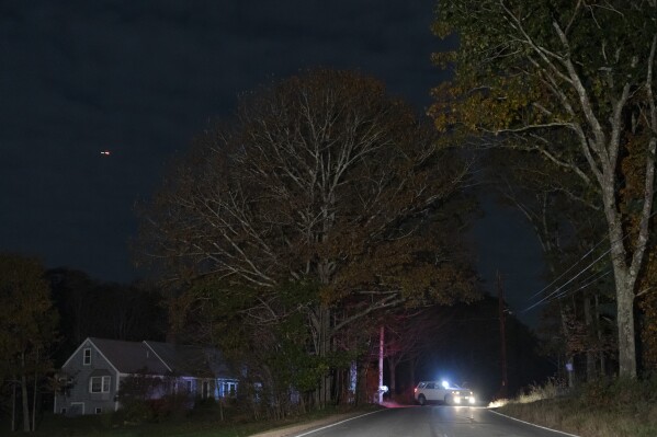 Un agente de la ley bloquea una carretera en Bowdoin, Maine, el jueves 26 de octubre de 2023, durante una búsqueda del sospechoso de un tiroteo masivo en Lewiston, Maine.  (Foto AP/Matt Rourke)