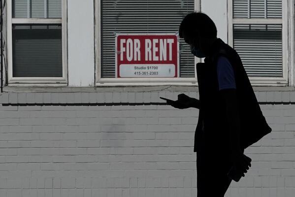 FILE - In this Oct. 20, 2020 file photo, a man walks in front of a For Rent sign in a window of a residential property in San Francisco. California has been slow to distribute rental assistance money for residents struggling during the coronavirus pandemic, and the state risks forfeiting hundreds of millions of dollars in federal funds, auditors said Thursday, Sept. 16, 2021. (AP Photo/Jeff Chiu, File)
