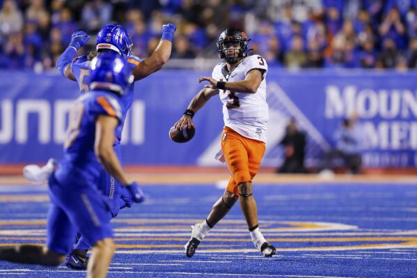 Oklahoma State quarterback Spencer Sanders (3) looks for a receiver as he is pressured by the Boise State defense during the second half of an NCAA college football game Saturday, Sept. 18, 2021, in Boise, Idaho. (AP Photo/Steve Conner)