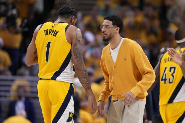 Injured Indiana Pacers guard Tyrese Haliburton talks with teammate forward Obi Toppin (1) during the second half of Game 3 of the NBA Eastern Conference basketball finals against the Boston Celtics, Saturday, May 25, 2024, in Indianapolis. (AP Photo/Michael Conroy)