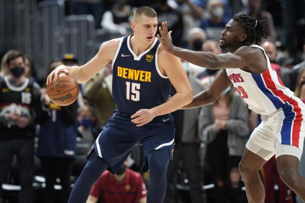 Denver Nuggets center Nikola Jokic, left, looks to drive to the rim as Detroit Pistons center Isaiah Stewart defends in the first half of an NBA basketball game, Sunday, Jan. 23, 2022, in Denver. (AP Photo/David Zalubowski)