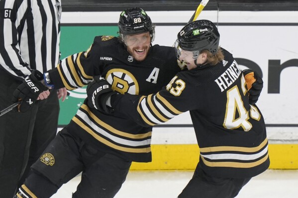 Boston Bruins right wing David Pastrnak (88) celebrates with left wing Danton Heinen (43) after scoring against the Ottawa Senators during the third period of an NHL hockey game Tuesday, March 19, 2024, in Boston. (AP Photo/Steven Senne)