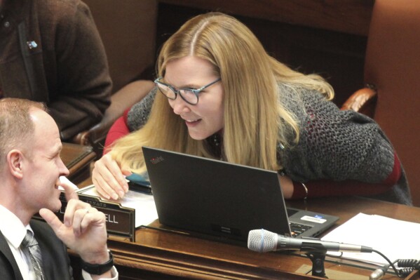 Democratic State Sen. Nicole Mitchell, right, of Woodbury, speaks with Sen. Robert D. Farnsworth, a Republican from Hibbing, on the floor of the Minnesota Senate on April 2, 2024, at the State Capitol in St. Paul, Minn. (AP Photo/Steve Karnowski)