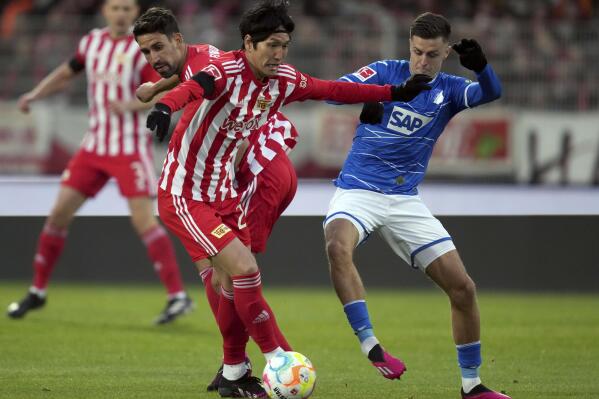 Union's Genki Haraguchi, left, and Hoffenheim's Christoph Baumgartner, right, challenge for the ball during the German Bundesliga soccer match between 1. FC Union Berlin and TSG 1899 Hoffenheim in Berlin, Germany, Saturday, Jan. 21, 2023. (AP Photo/Michael Sohn)