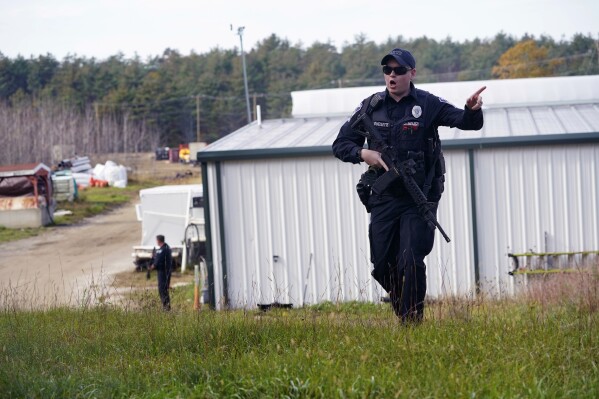 A police officer gives an order to the public during a manhunt for Robert Card at a farm following two mass shootings, Oct. 27, 2023, in Lisbon, Maine. (AP Photo/Robert F. Bukaty, File)