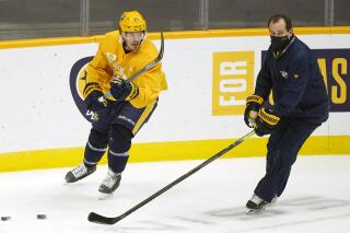 FILE - In this Jan. 4, 2021, file photo, Nashville Predators center Nick Cousins (21) runs a drill with assistant coach Todd Richards, right, during an NHL hockey training camp in Nashville, Tenn. Richards, former Minnesota and Columbus head coach, is recovering from a heart attack. The Predators announced Monday, Oct. 4, 2021, that Richards had the attack Friday. Richards has been released from the hospital and is resting at home in Nashville. (AP Photo/Mark Humphrey, File)
