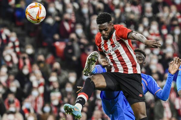 FILE - Athletic Bilbao's Inaki Williams, left, fights for the ball with Valencia's Mouctar Diakhaby during a Spanish Copa del Rey semifinal first leg soccer match between Athletic Club and Valencia at the San Mames stadium in Bilbao, Spain, on Feb. 10, 2022. Spain-born Williams said Tuesday, July 5, he will play for Ghana's national team. The Athletic Bilbao forward made the announcement through a video posted on his social media accounts. (AP Photo/Alvaro Barrientos, File)