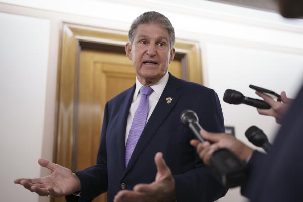 FILE - Sen. Joe Manchin, D-W.Va., is met by reporters outside the hearing room where he chairs the Senate Committee on Energy and Natural Resources, at the Capitol in Washington, July 21, 2022. Manchin has been an obstacle for Biden's climate change plans, a reflection of his outsized influence at a time when Democrats hold the narrowest of margins in the U.S. Senate. (AP Photo/J. Scott Applewhite, File)