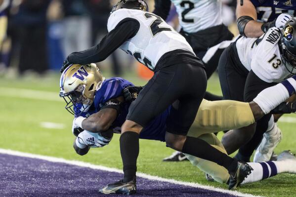 Washington running back Jay'Veon Sunday scores a touchdown against Colorado defensive back Jason Oliver during the second half of an NCAA college football game Saturday, Nov. 19, 2022, in Seattle. Washington won 54-7. (AP Photo/Stephen Brashear)