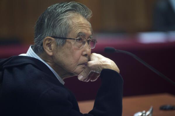 FILE - Peru's jailed, former President Alberto Fujimori, photographed through a glass window, attends his trial at a police base on the outskirts of Lima, Peru, June 28, 2016. A Peruvian judge on Thursday, March 24, 2022, banned Fujimori from leaving the country for 18 months upon his released from prison where he is serving a 25-year sentence for murder. (AP Photo/Martin Mejia, File)