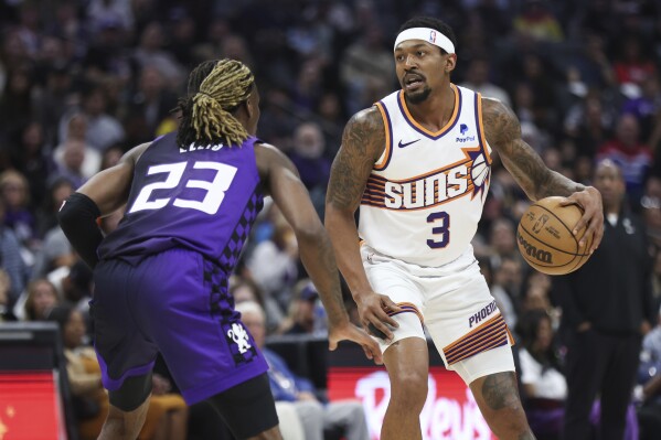 Sacramento Kings guard Keon Ellis (23) defends against Phoenix Suns guard Bradley Beal (3) during the first half of an NBA basketball game Friday, April 12, 2024, in Sacramento, Calif. (AP Photo/Benjamin Fanjoy)
