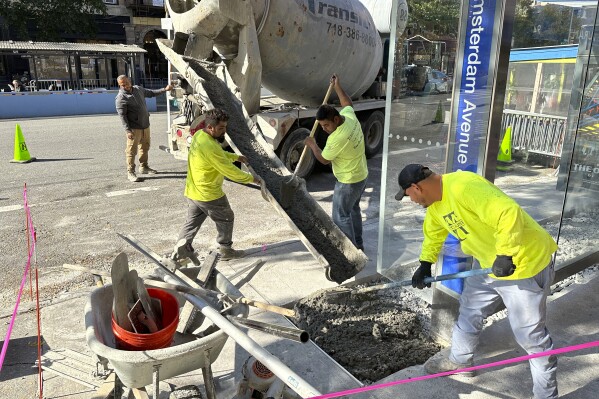 Workers pour concrete to create part of a bus stop in the Manhattan borough of New York City on Thursday, October 12, 2023. On Friday, the U.S. government issues the October jobs report. (AP Photo/Ted Shaffrey)