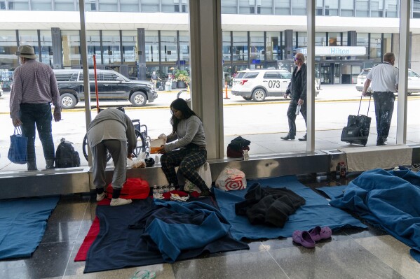 FILE - Run by a private firm hired by the city, migrants stay in a makeshift shelter at O'Hare International Airport, Sept. 20, 2023, in Chicago. Five mayors from around the U.S. want a meeting with President Joe Biden to ask for help controlling the continued arrival of large groups of migrants to their cities. The mayors of Denver, Chicago, Houston, New York and Los Angeles say in a letter to Biden that there has been little to no coordination, support or resources and that is leading to a crisis. (AP Photo/Erin Hooley, File Photo)